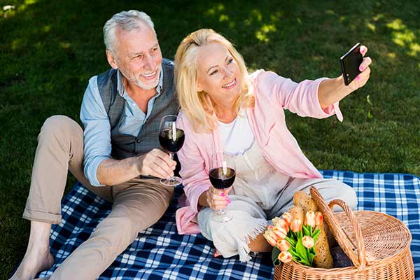 Happy senior couple walking hand in hand at Sydney Harbour - mature dating Australia